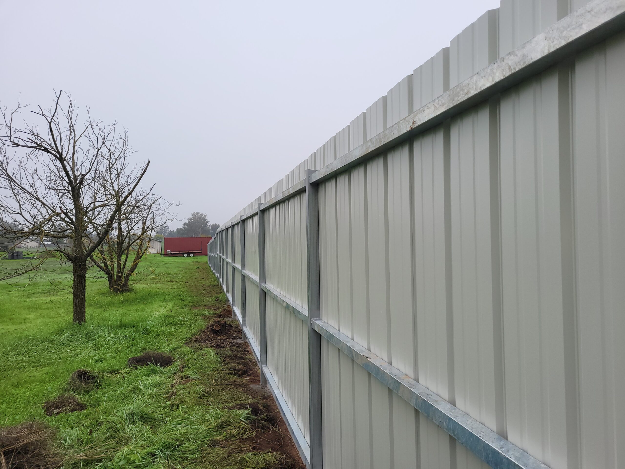 Galvanized steel posts and three rails carrying corrugated metal panels, Elverta