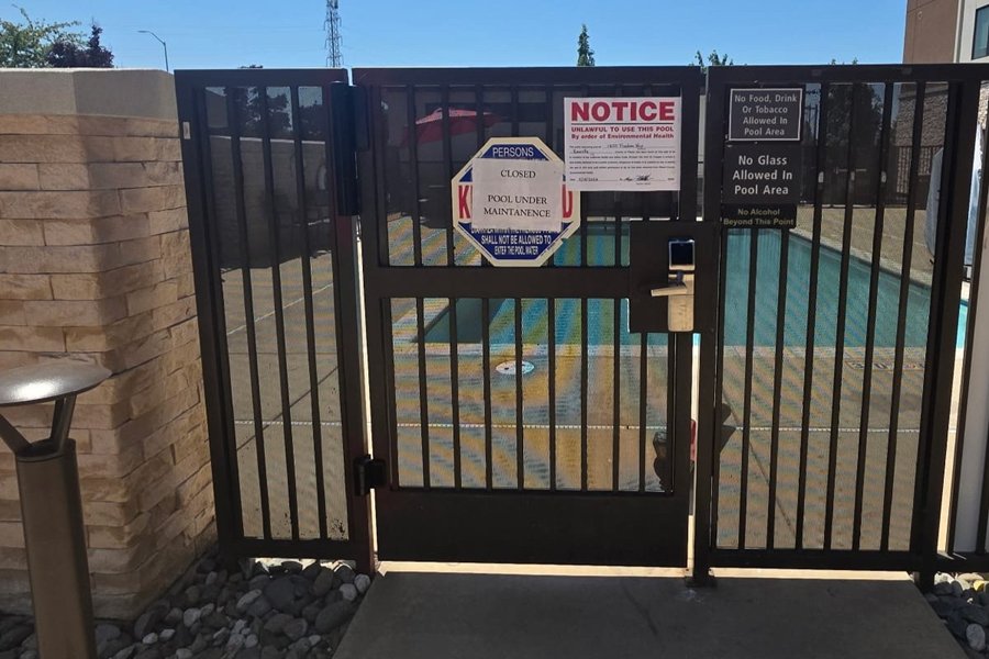 Black ornamental iron pool gate Palmer Fence relocated and rehung at a Home2 Suites by Hilton in Roseville