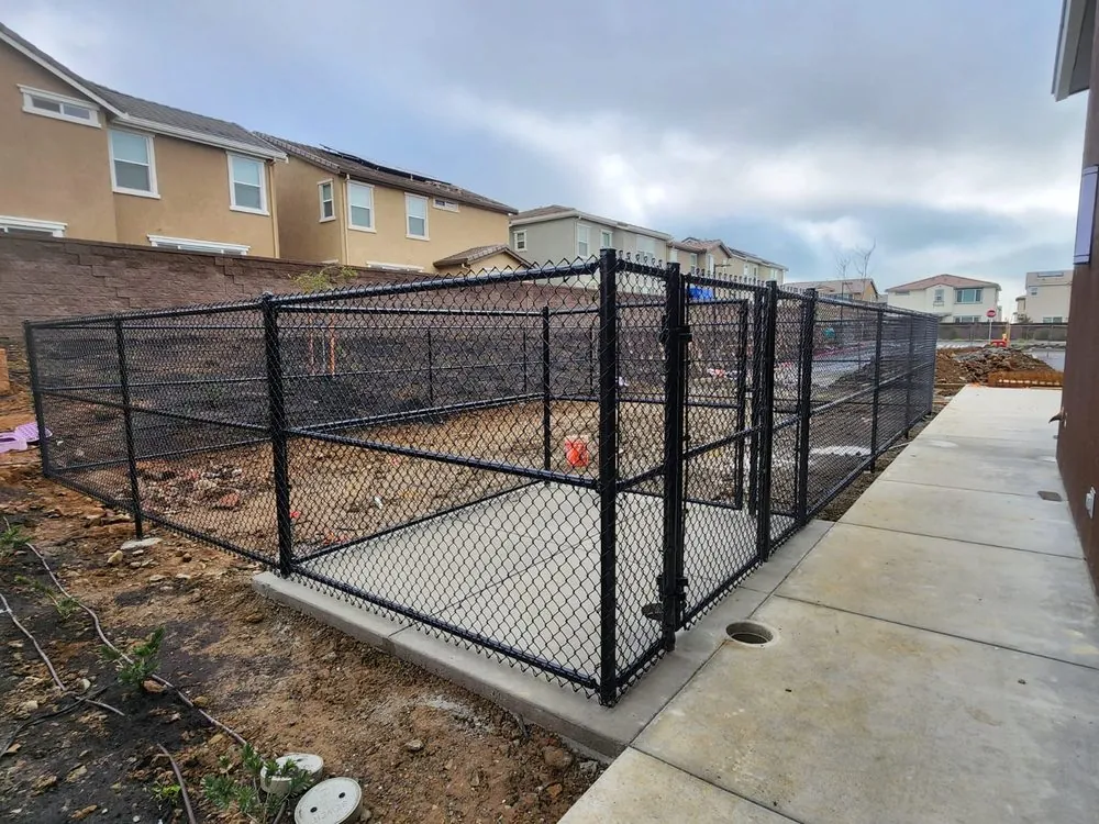 Black vinyl-coated commercial chain link enclosure and gate built by Palmer Fence in the Sacramento area