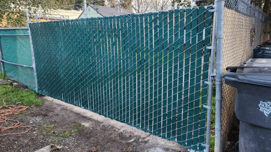 Commercial chain link fence with green privacy slats by Palmer Fence in the Sacramento area
