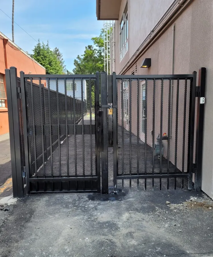 Black double gate with expanded metal infill at a commercial building, built by Palmer Fence in Sacramento