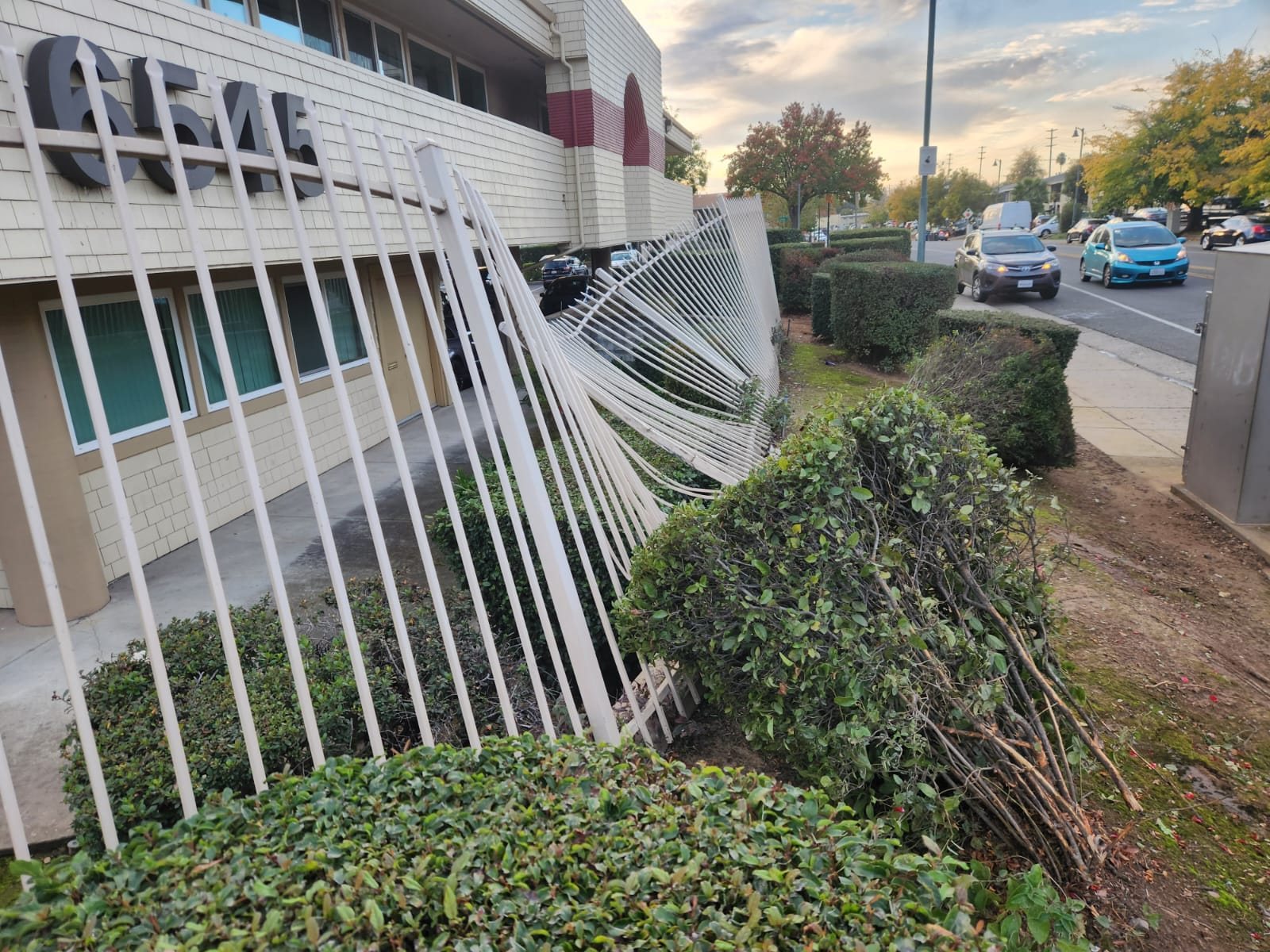 Ornamental iron fence panel bent and pushed over by a vehicle at a Sacramento commercial property, before repair by Palmer Fence