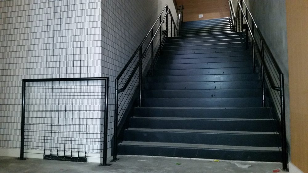 Black steel commercial stair railing in a Sacramento-area stairwell, built by Palmer Fence