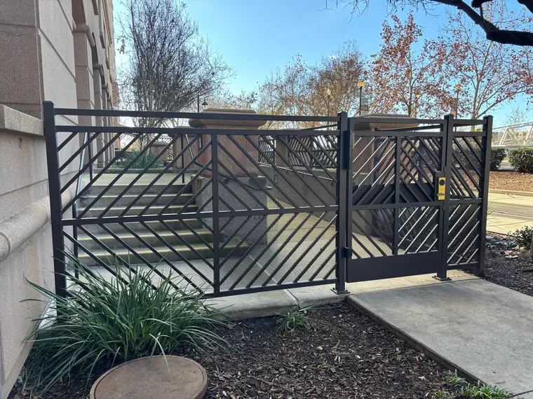 Custom bronze metal pedestrian gate with card-reader lock hardware, fabricated by Palmer Fence in Sacramento