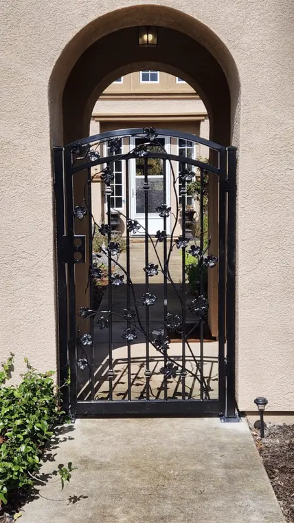 Custom ornamental iron pedestrian gate with vine and leaf design fabricated by Palmer Fence