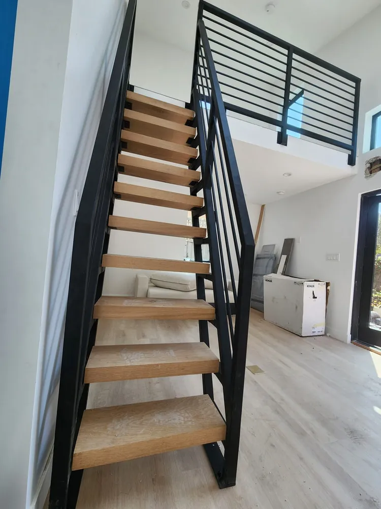 Custom steel and wood open-riser staircase with steel railing, built by Palmer Fence in the Sacramento area