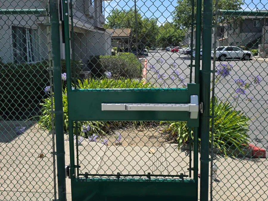 Chain link man gate with Apollo panic bar and Locinox hinges at a Davis tennis court