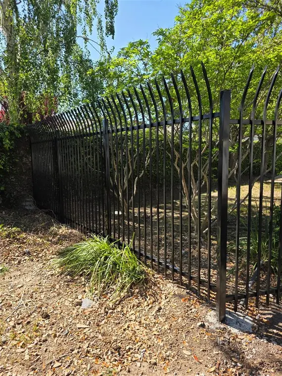 Curved-top black ornamental iron fence run installed by Palmer Fence in Elk Grove