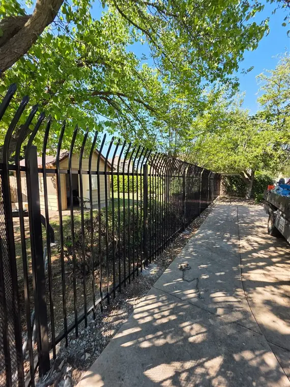 Black ornamental iron perimeter fence along a walkway in Elk Grove, by Palmer Fence