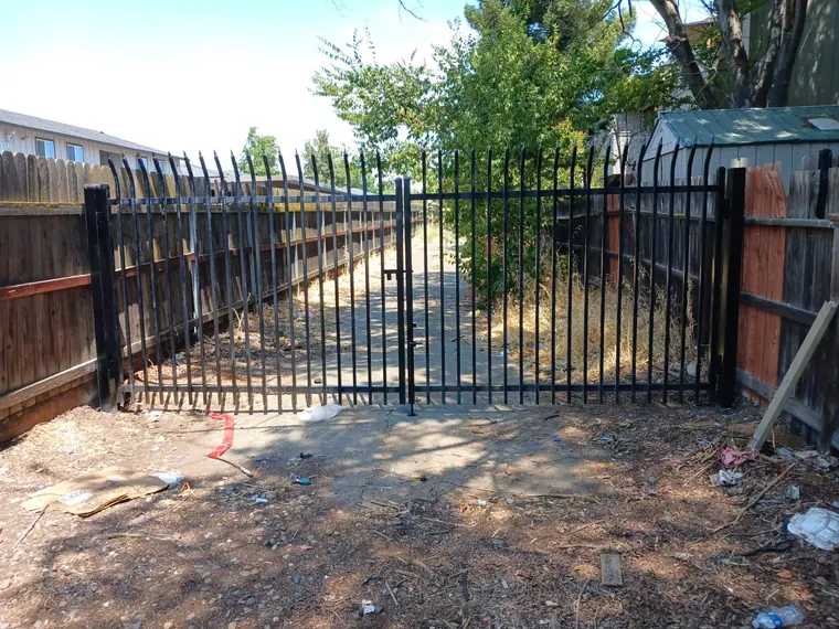 Black iron sliding gate with a pedestrian gate, built by Palmer Fence in Sacramento