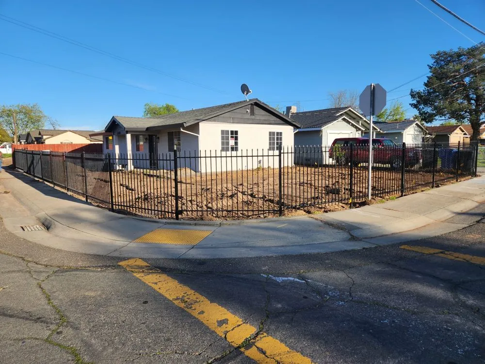 Black ornamental iron fence around a corner-lot property in Sacramento, built by Palmer Fence
