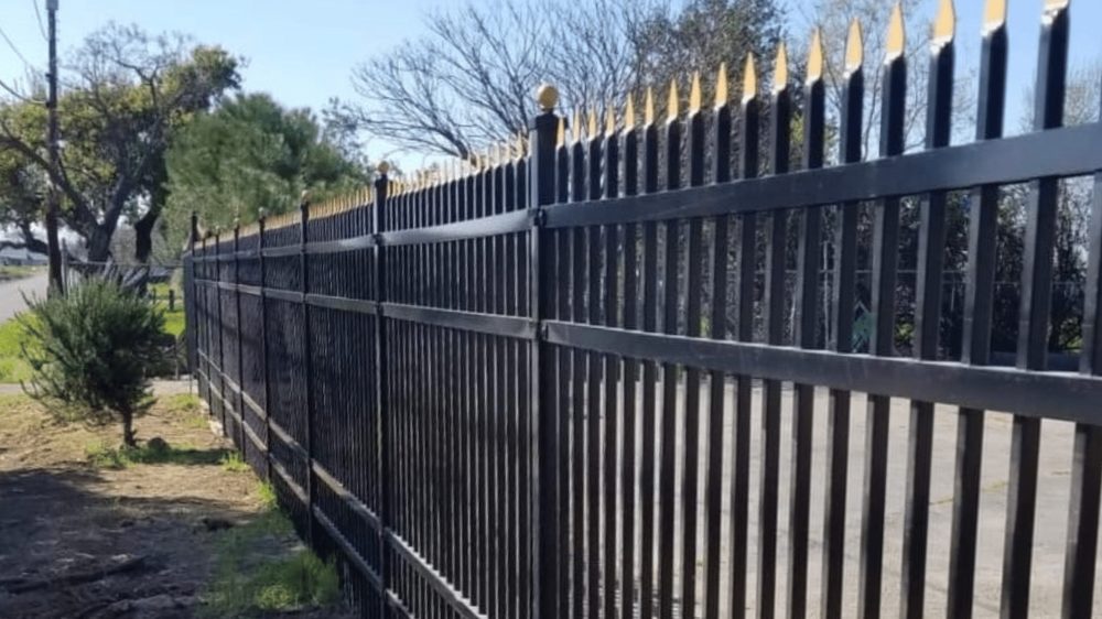 Black ornamental iron fence with gold-tipped spear finials, built by Palmer Fence near Sacramento