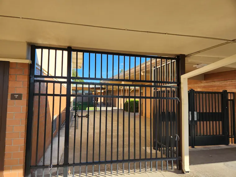 Black steel security gates closing off a school corridor in the Sacramento area, by Palmer Fence