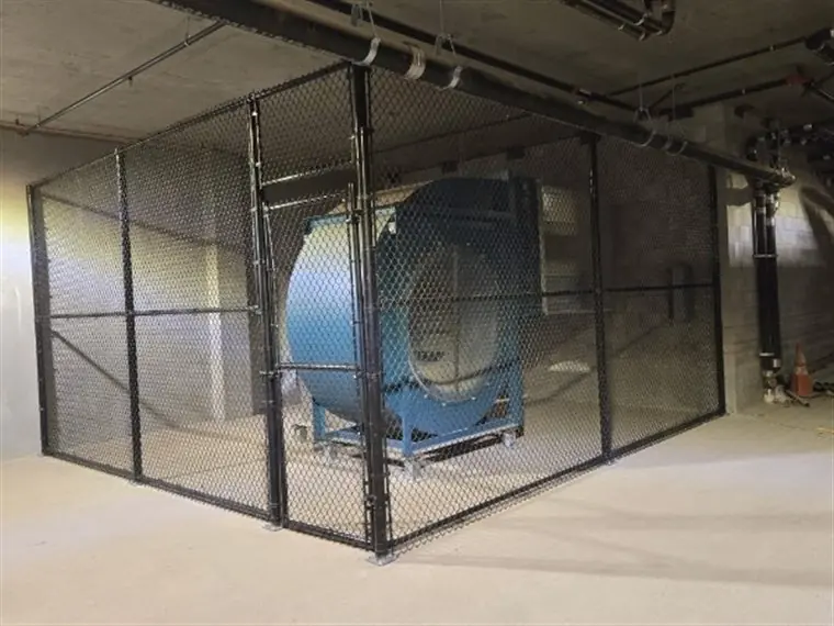 Black chain-link security enclosure built by Palmer Fence at a West Sacramento facility